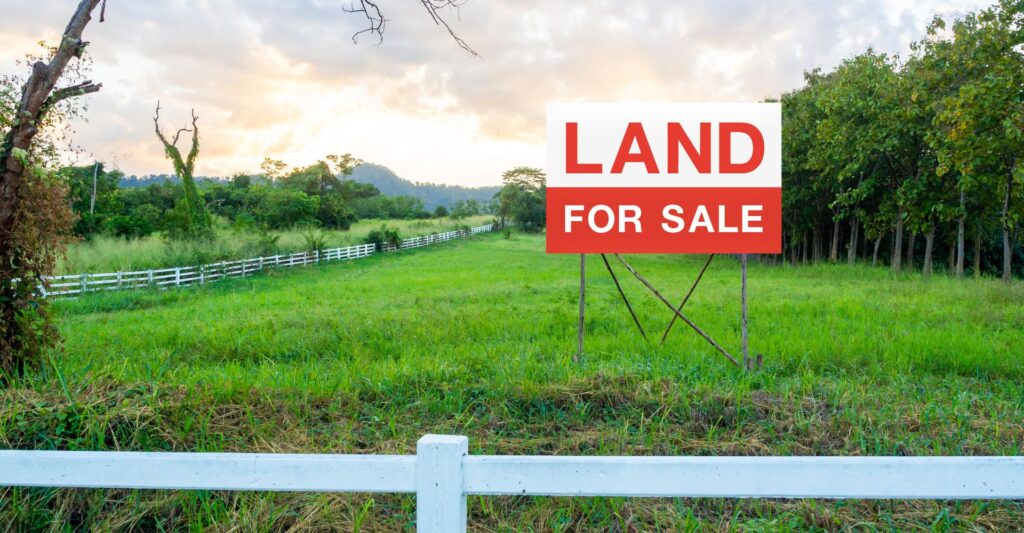land for sale sign in the middle of an open field